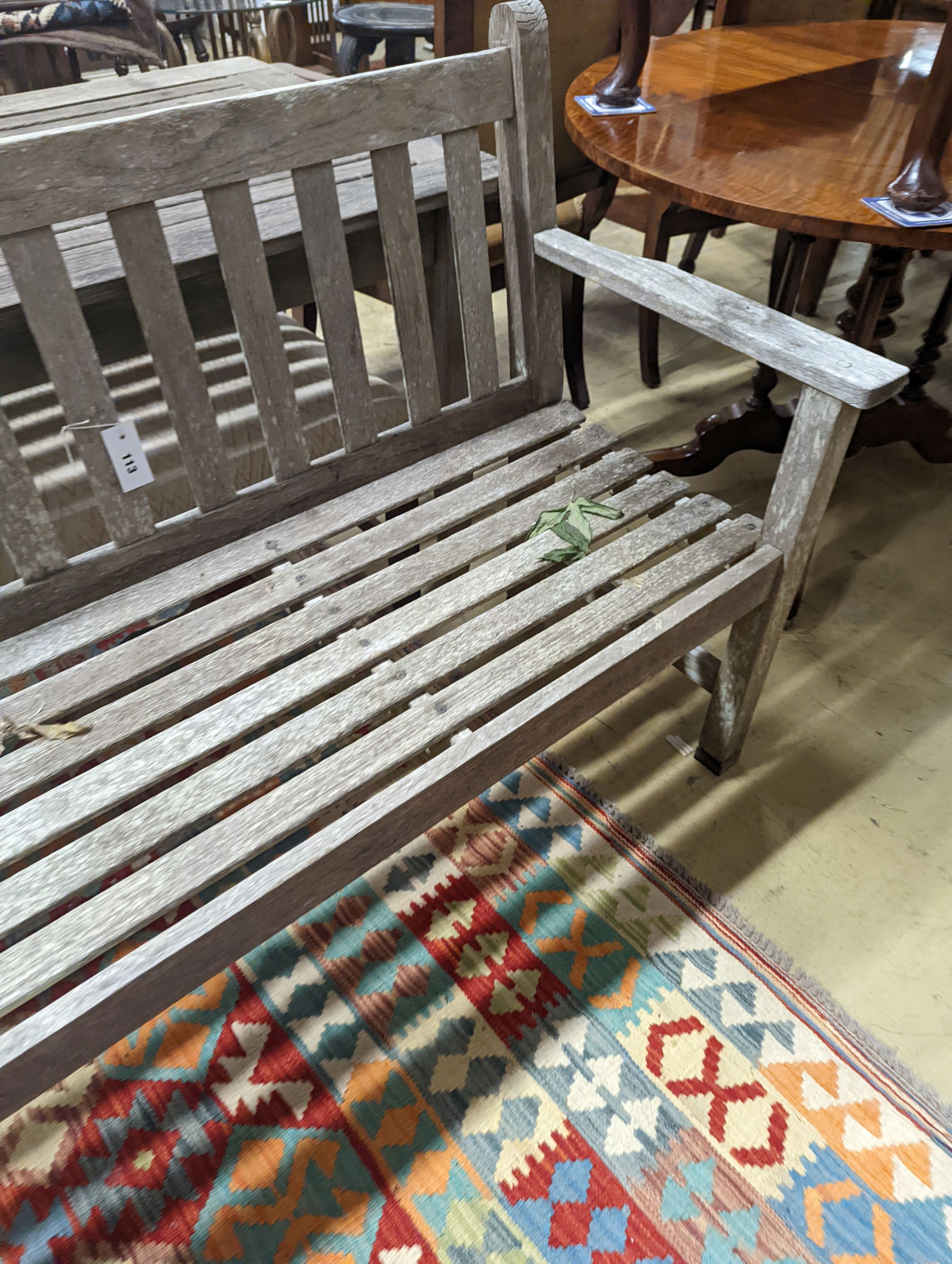 A Barlow type weathered teak garden suite, comprising rectangular table, length 149cm, depth 71cm, height 70cm, a bench and two armchairs